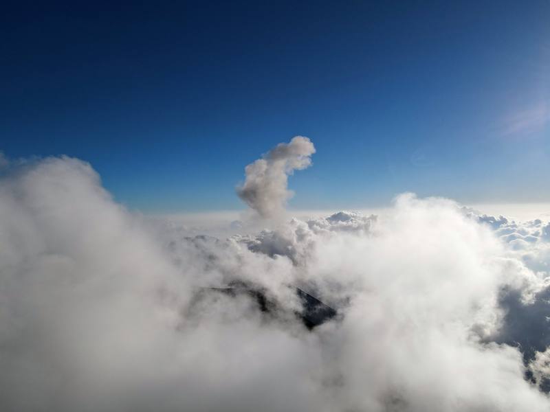 Fuego's summit and a puff of ash above the clouds, from near the saddle below Acatenango's summit, Day 1 mile 4.4.